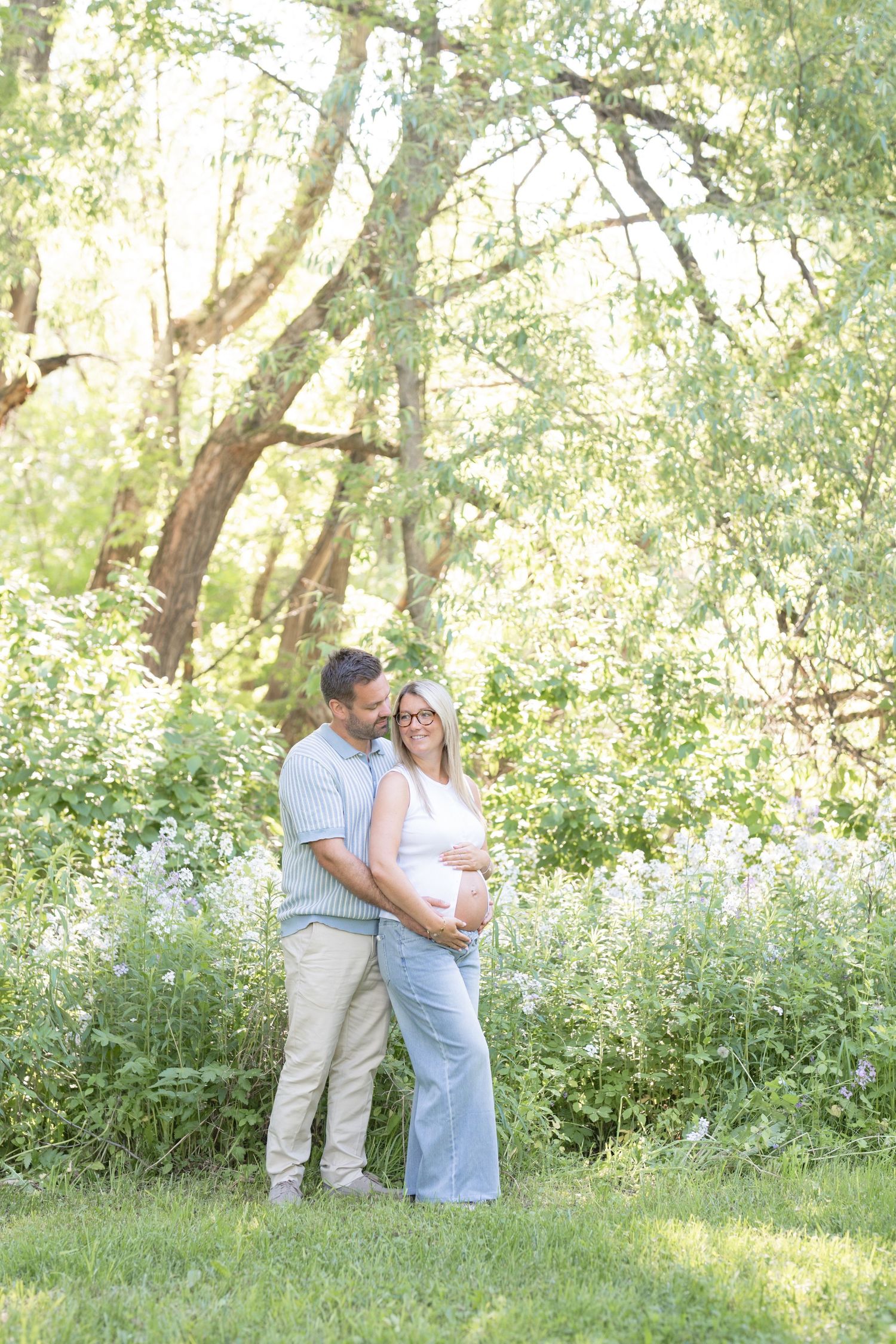 Couple de futurs parents sous les arbres d'un boisé à Saint-Augustin-de-Desmaures lors d'une séance photo de maternité