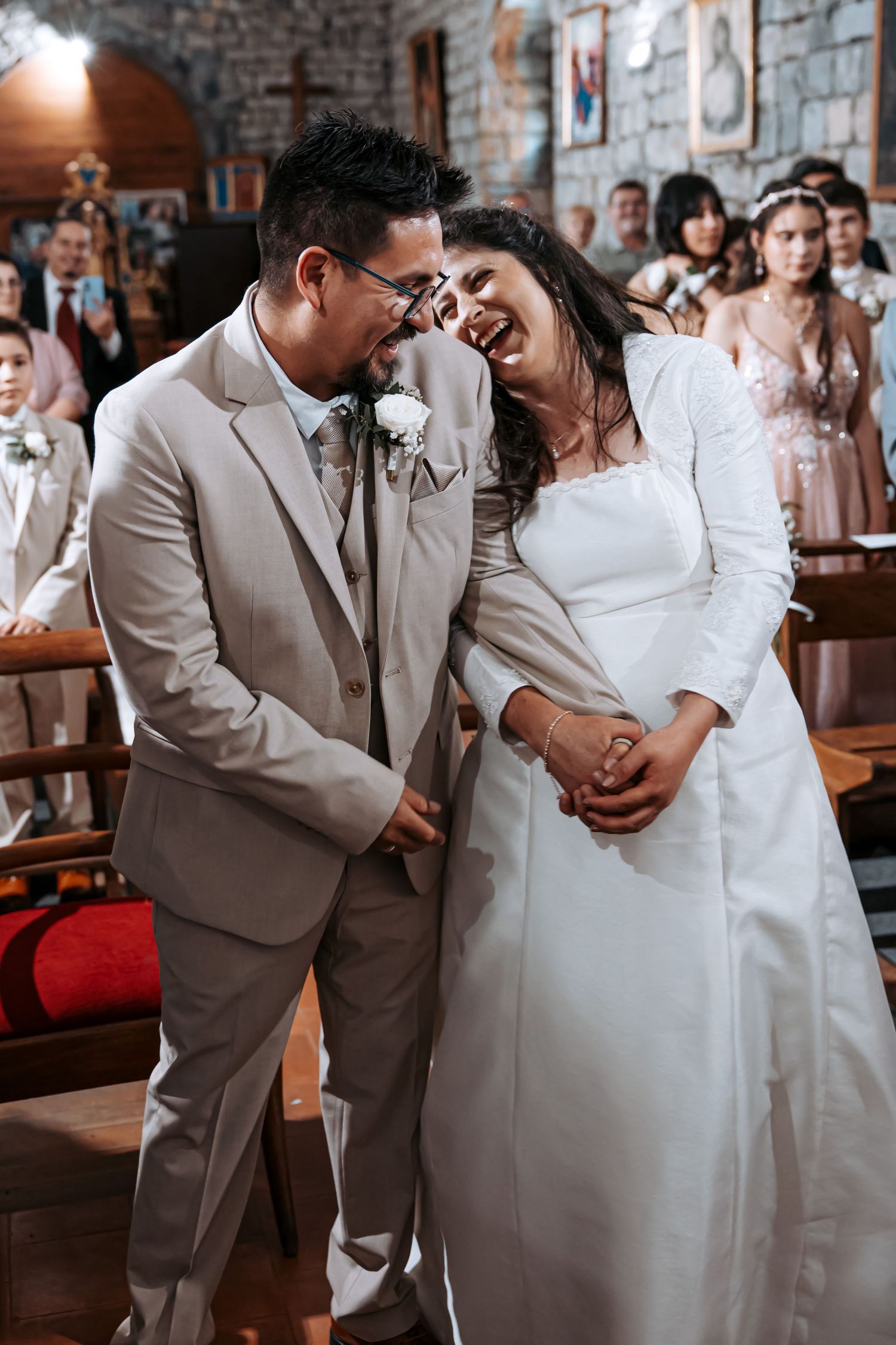 Bride and groom share a joyful laugh at the altar during their church wedding ceremony.