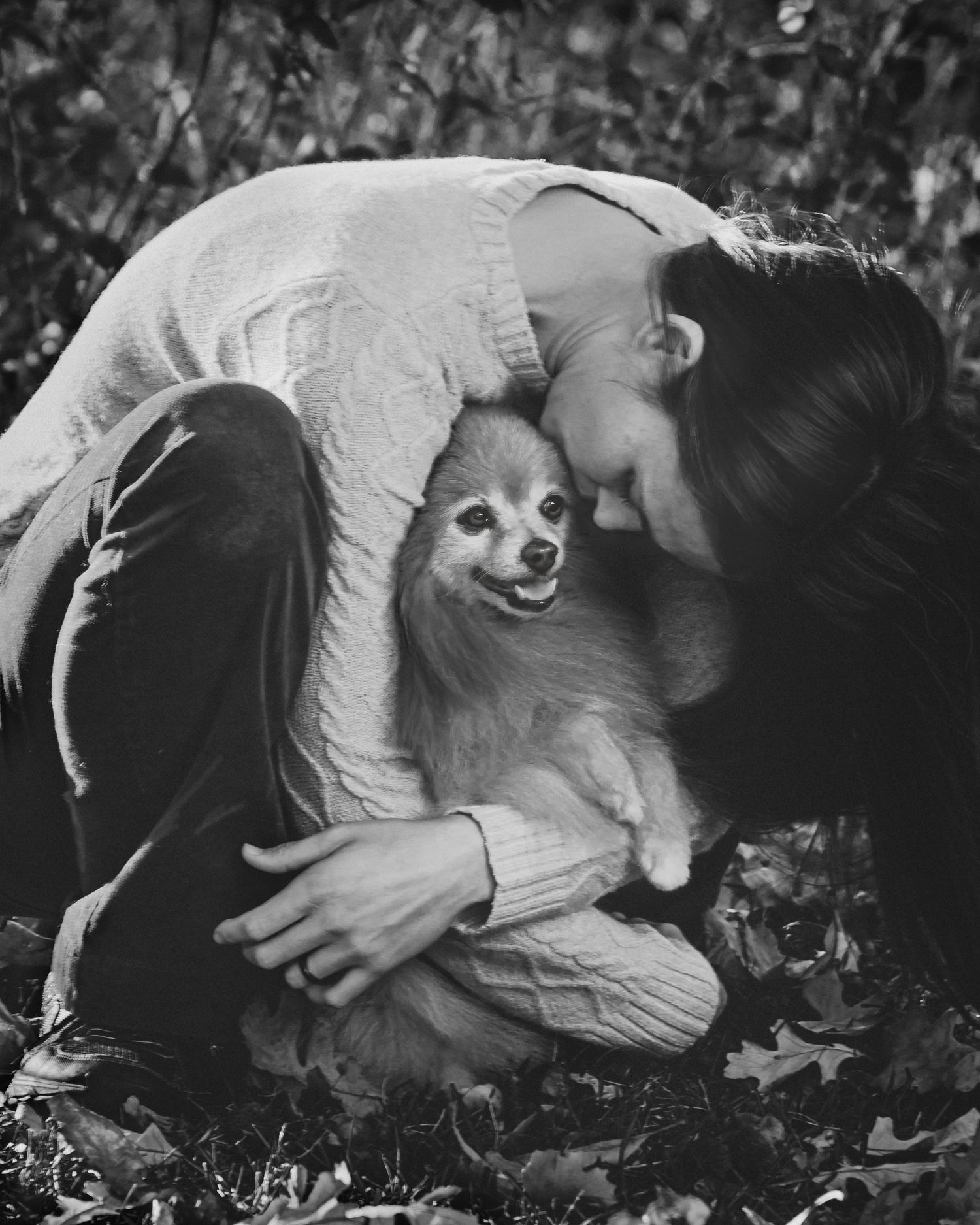 Black and white photo of a woman tenderly resting her head beside a dog, titled A Love Story, award-winning pet portrait.