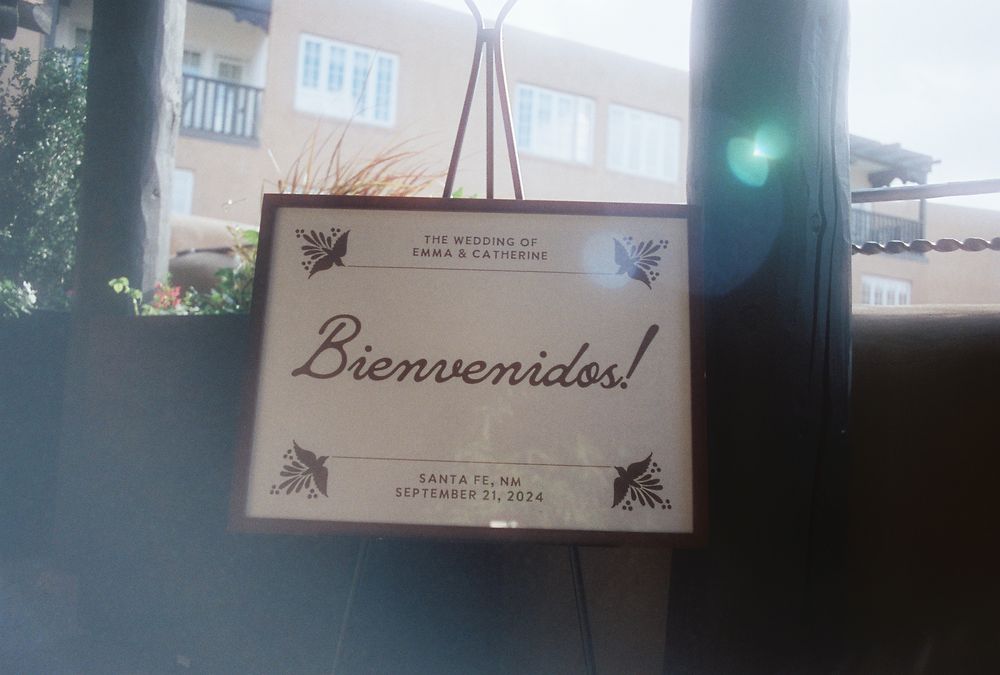 A framed Bienvenidos wedding welcome sign for Emma & Catherine in Santa Fe, NM, September 2024.