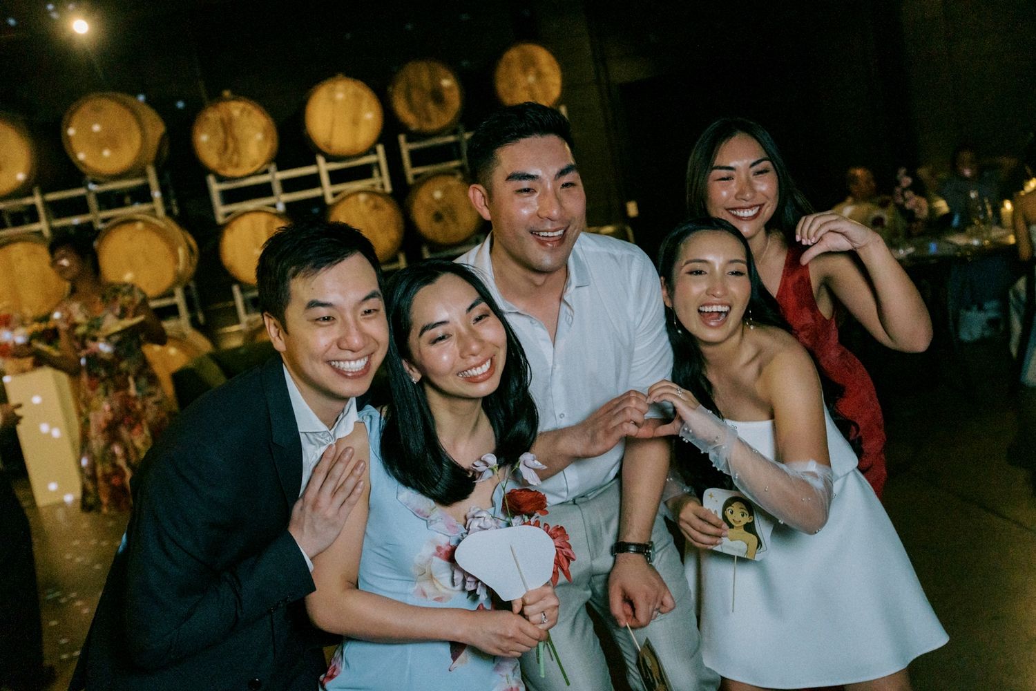 Group of five young Asian friends smiling and posing together at a winery wedding reception event at the bethnal. Newstead Brisbane