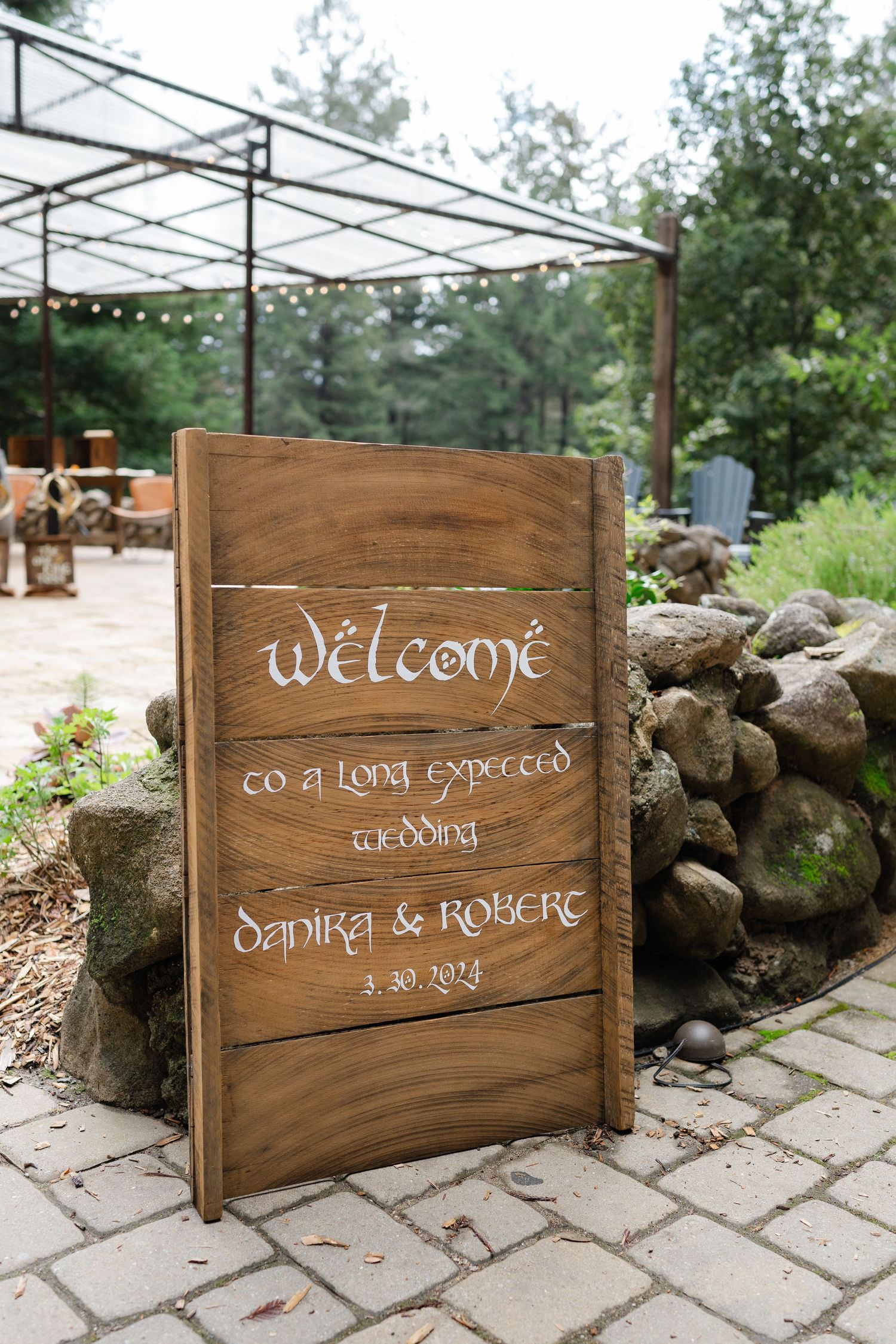 Rustic wooden wedding welcome sign reading Welcome to a Long Expected Wedding for Danira and Robert dated 3-30-2024.
