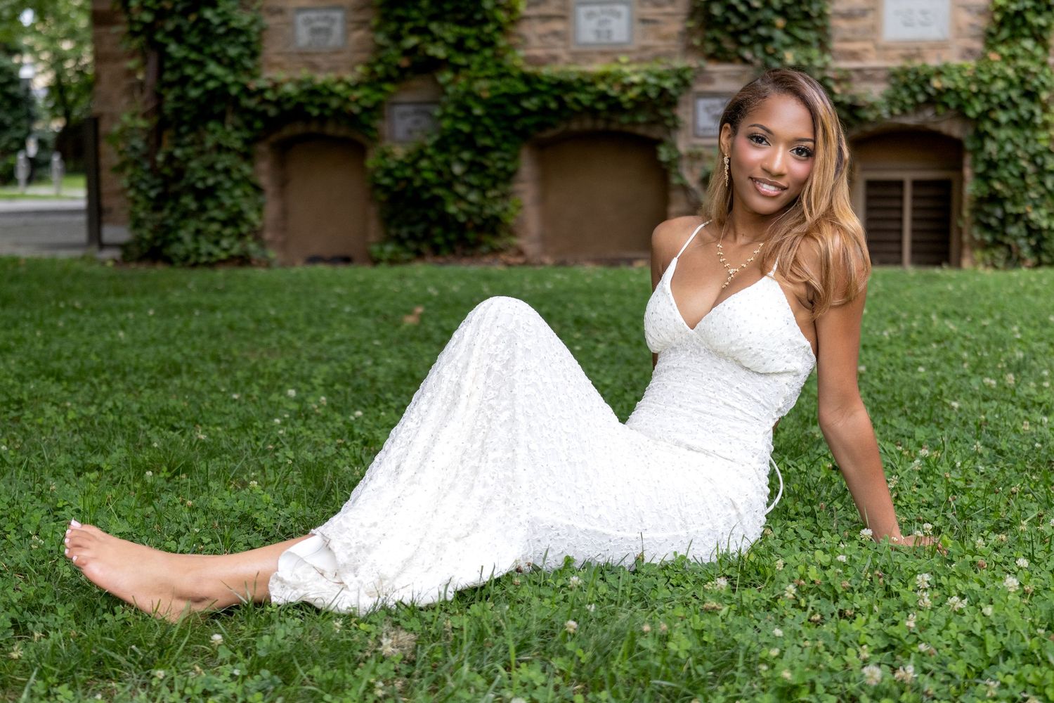 Woman in a white dress relaxing on the lawn in front of ivy walls, Princeton NJ portrait photographer