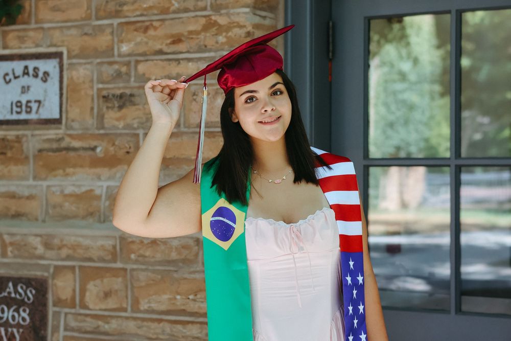 College graduate in a red cap and flag stole smiling, Central NJ graduation portrait photographer