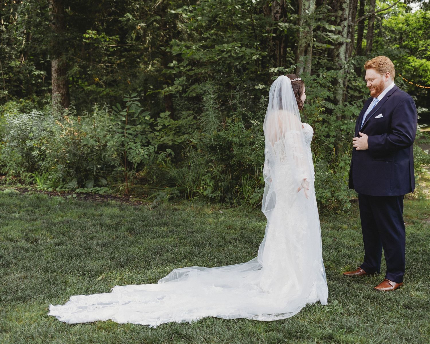 Couple smiling at each other during first-look wedding portraits.
