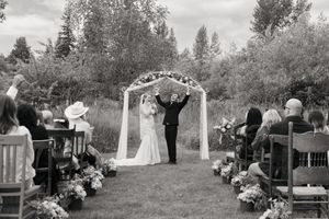 Black and white outdoor wedding ceremony with couple at floral arch, Sadie Lake Events, Captured by Savvy Photography