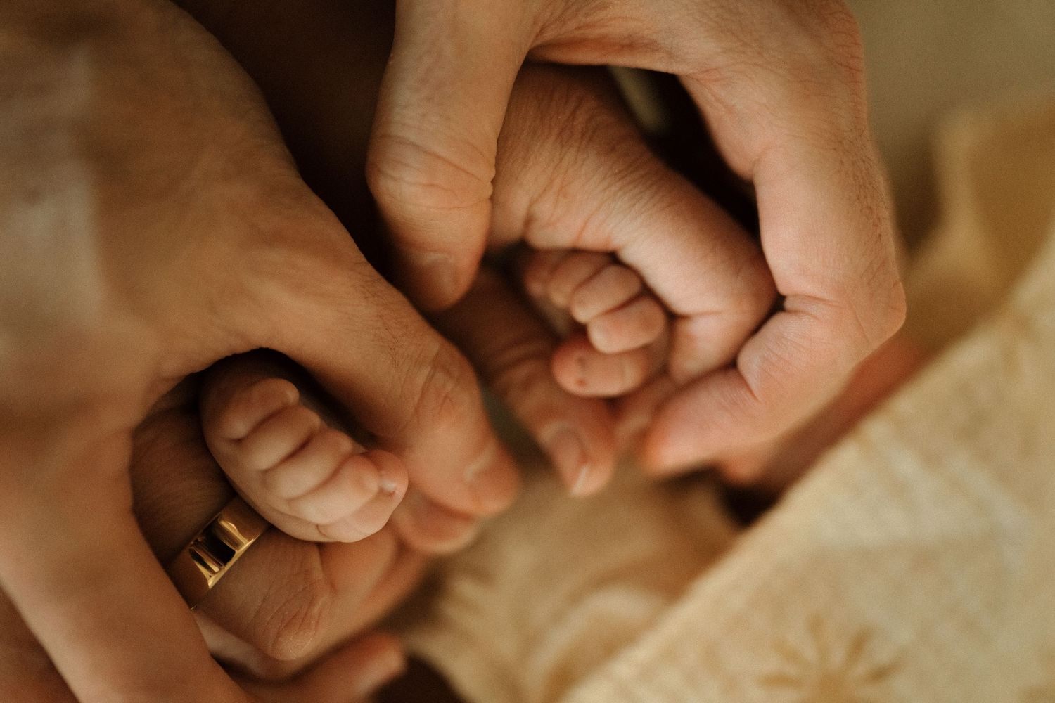 New parents tenderly holding their sleeping newborn baby dressed in pink during newborn session in Wicker Park
