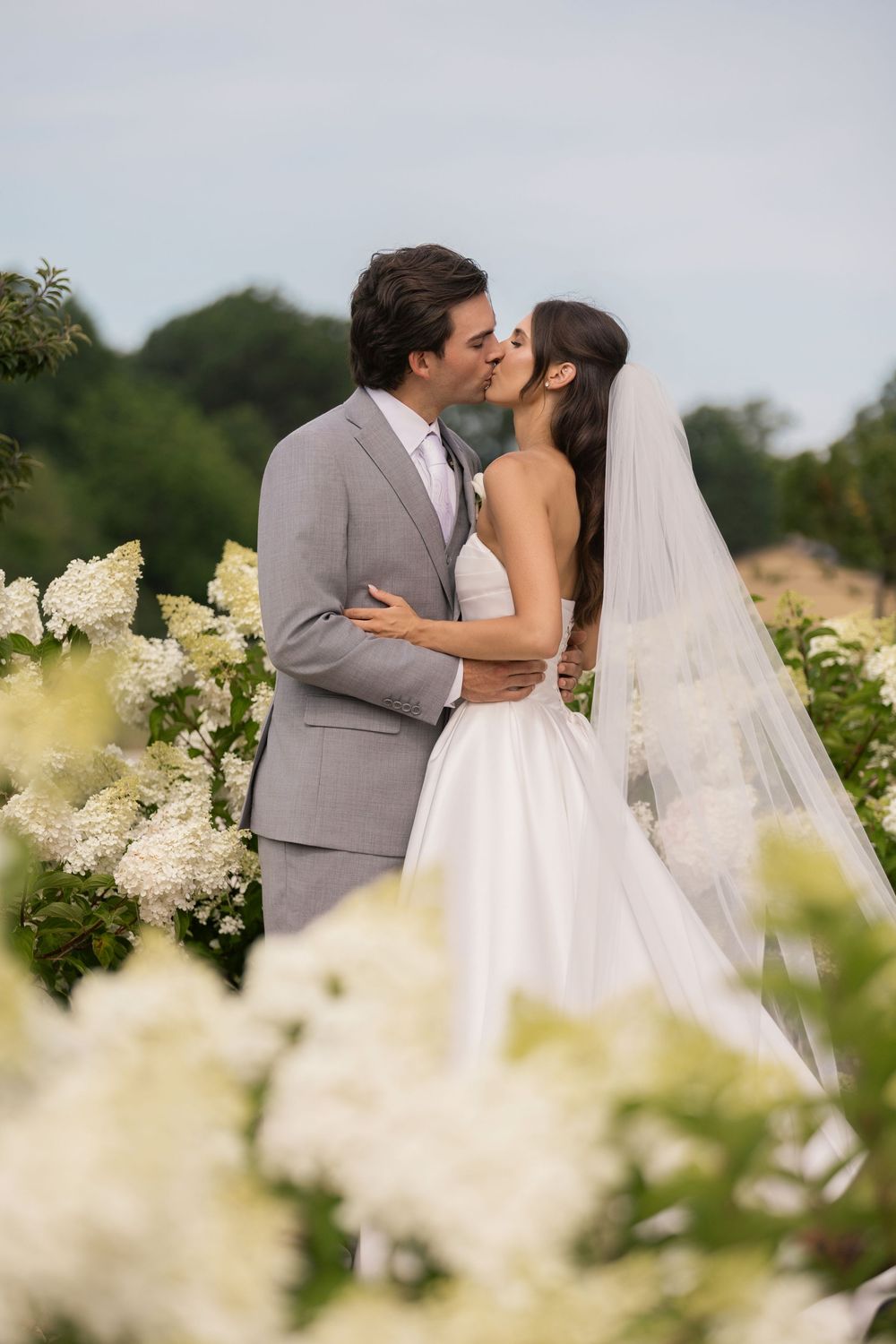 Bride and groom portrait surrounded by blooming hydrangeas at Tall Oaks Resort in Sheffield Village, Ohio