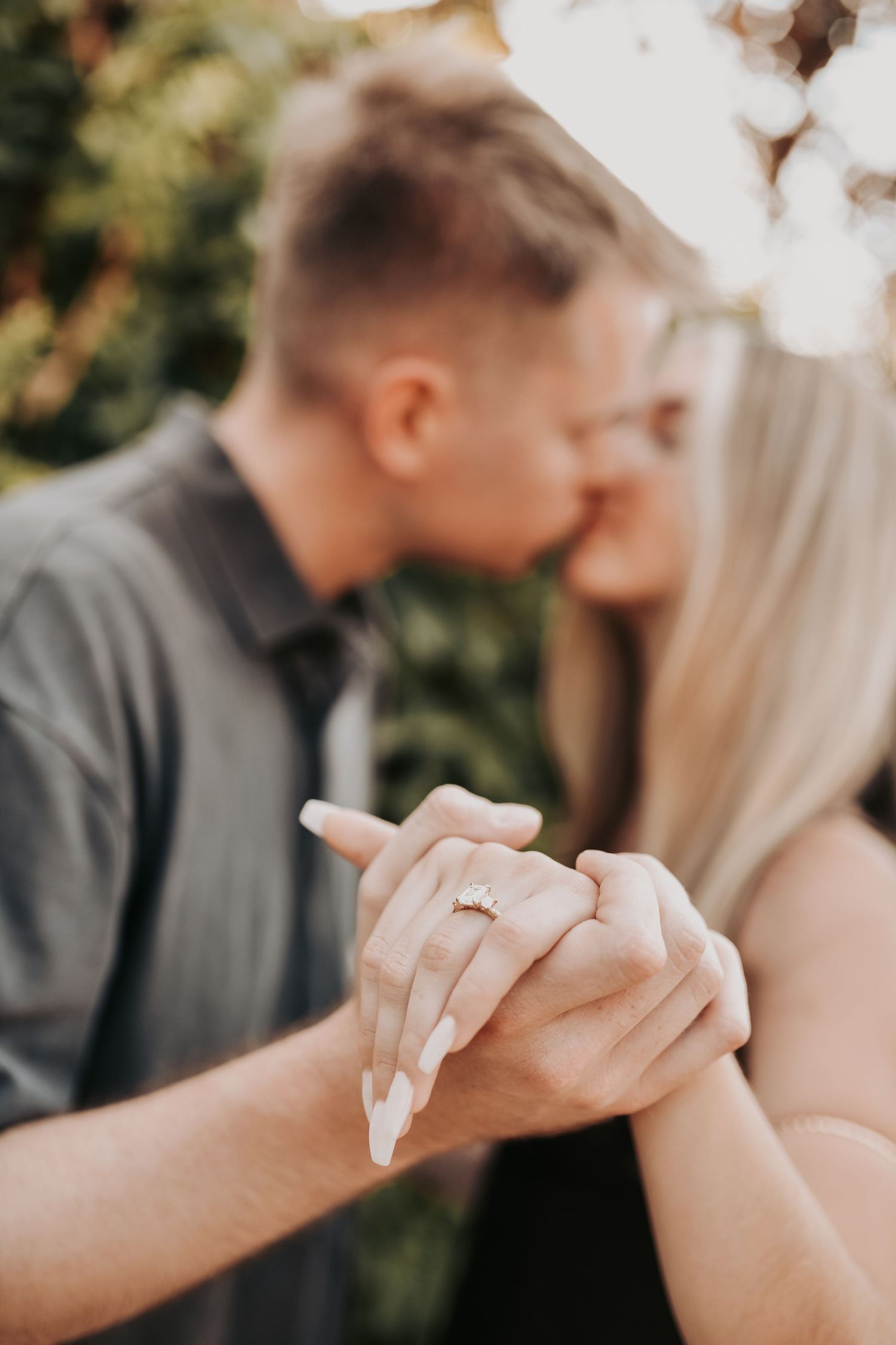 Newly engaged woman admiring her engagement ring in golden light
