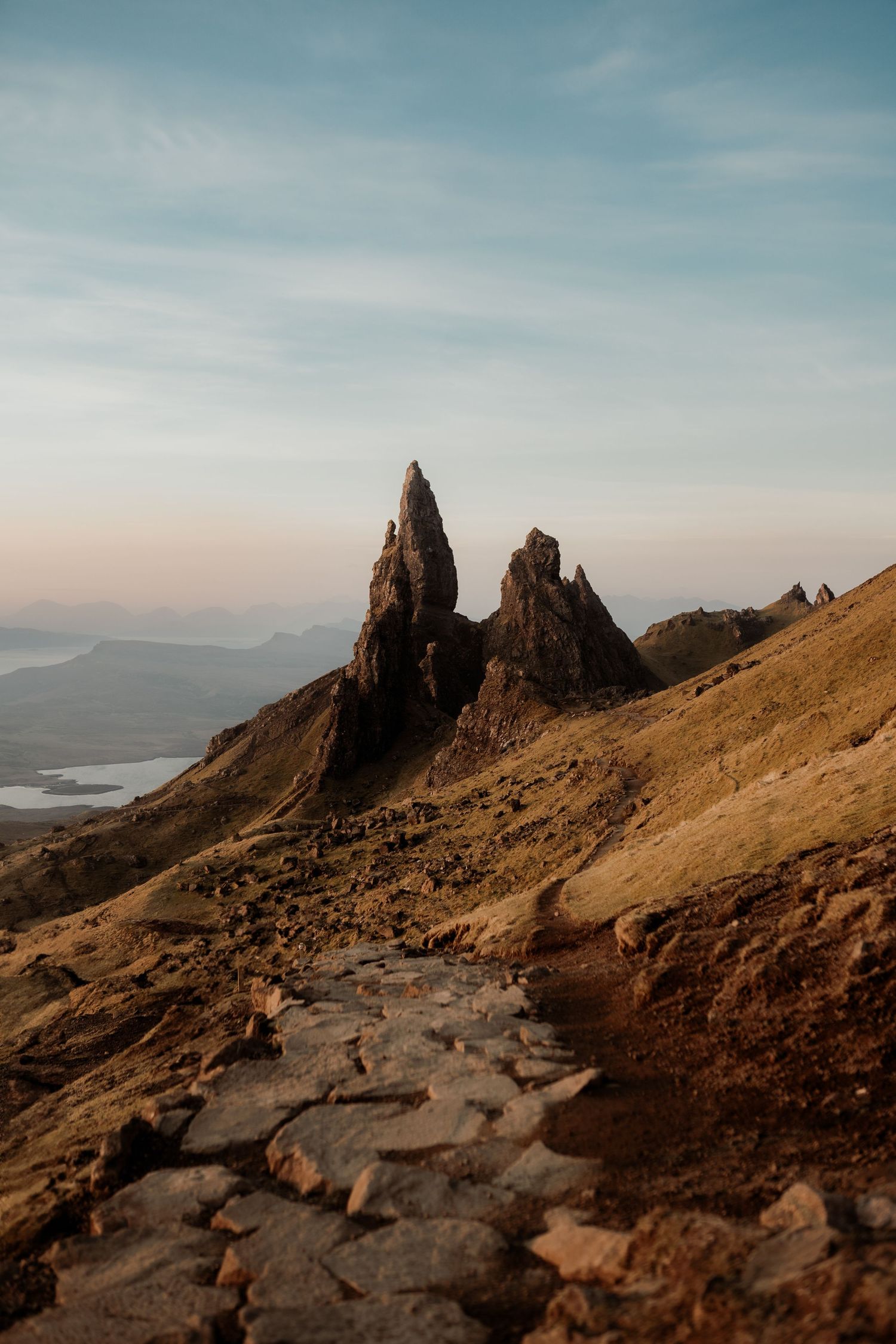 Rocky path leading to the Old Man of Storr pinnacles at golden hour on the Isle of Skye, Scotland.