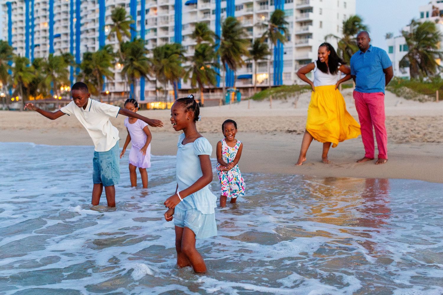 Family portrait. Mom, dad, and four kids enjoying the ocean at the beach in Isla Verde, Carolina, Puerto Rico.