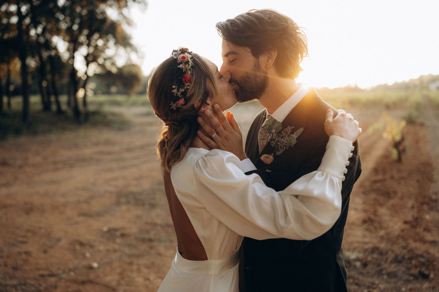 A romantic sunset wedding portrait with soft backlighting in a garden setting.