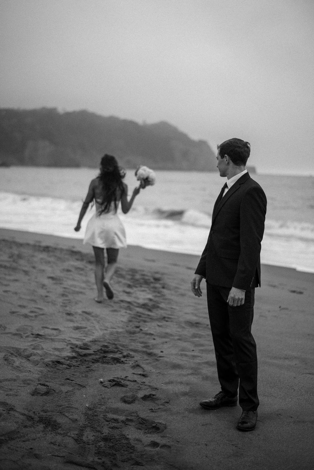 An intimate beach elopement with the Golden Gate behind them—windy, wild, romantic, and completely in the moment.