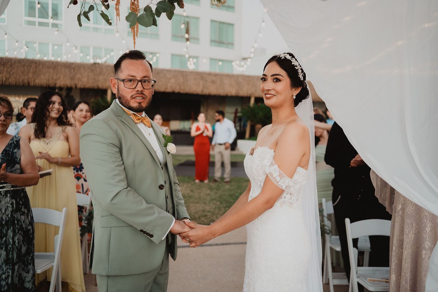 Novios tomados de las manos durante su ceremonia en Mazatlán.