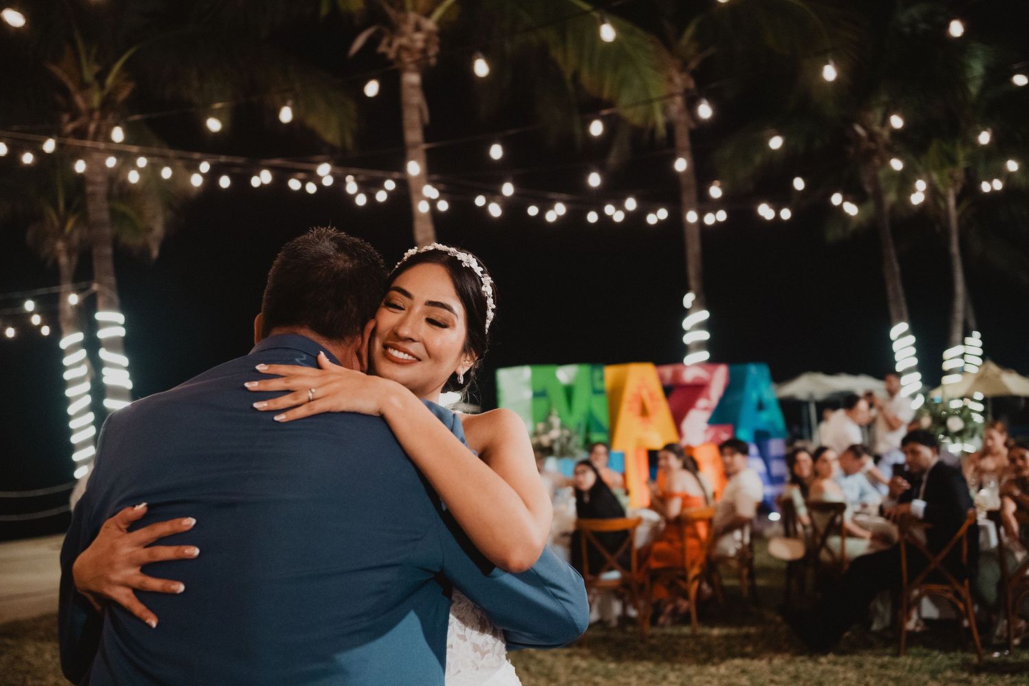 Novia sonriendo durante un abrazo en la recepción.
