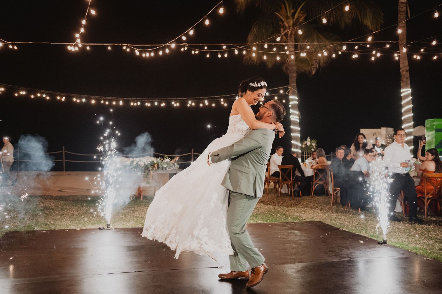 Novio levantando a la novia durante el baile entre chisperos.