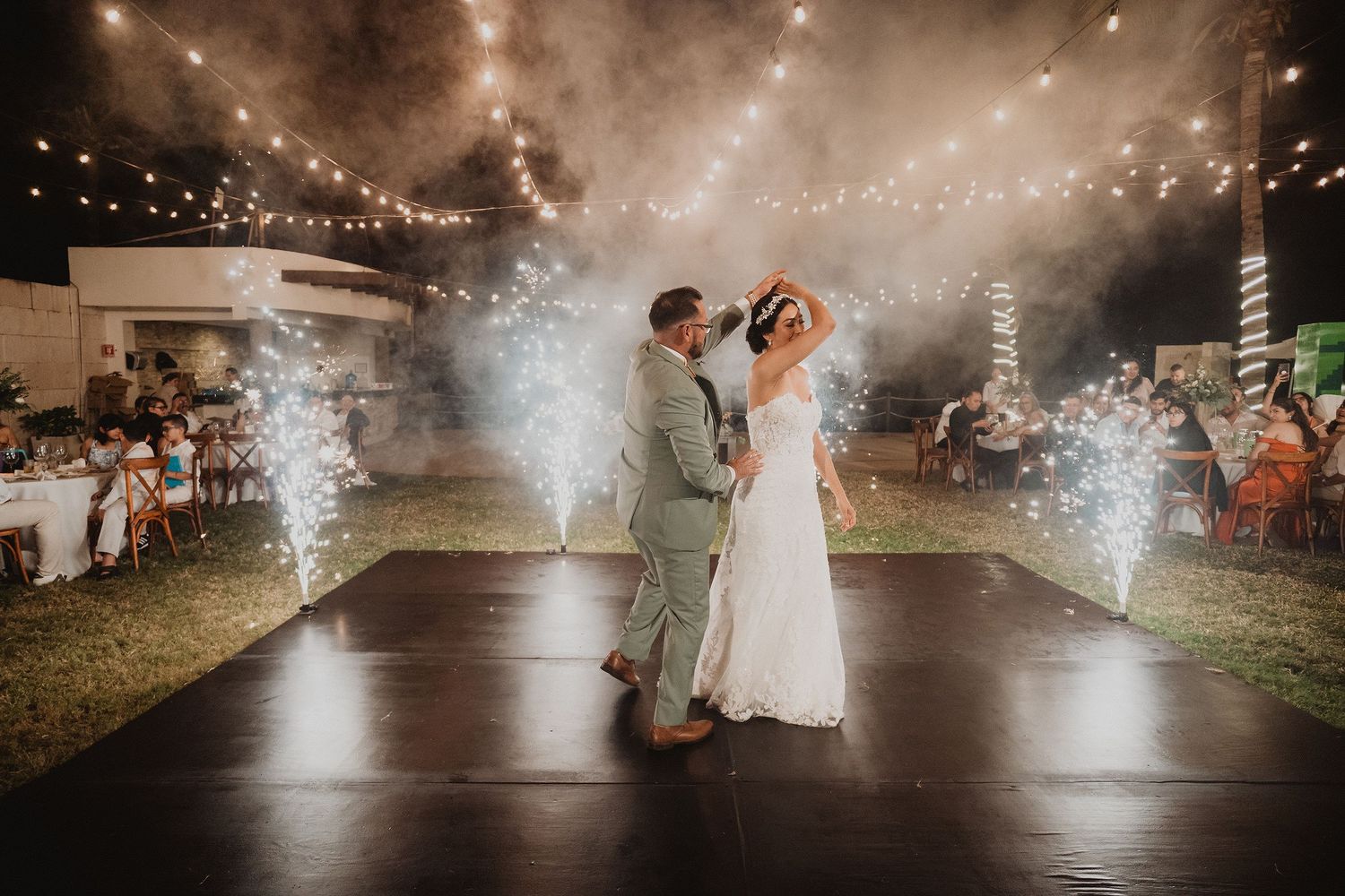 Novios bailando entre chisperos durante su boda en Mazatlán.