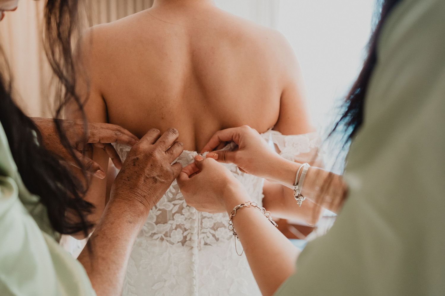 Detalle de las manos ajustando el vestido de novia.