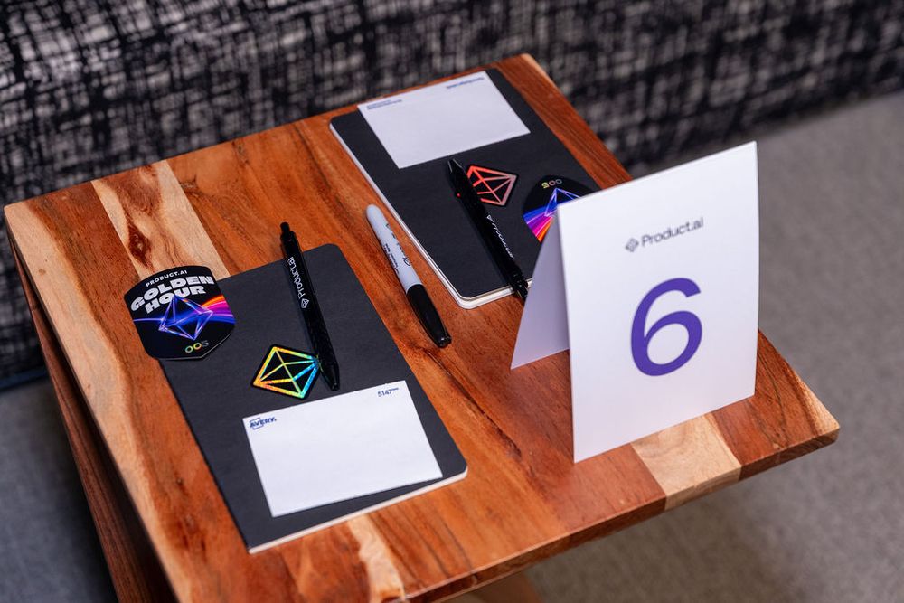 Table number 6 sign with notebooks, pens, and colorful stickers at a PocketLaw corporate event.