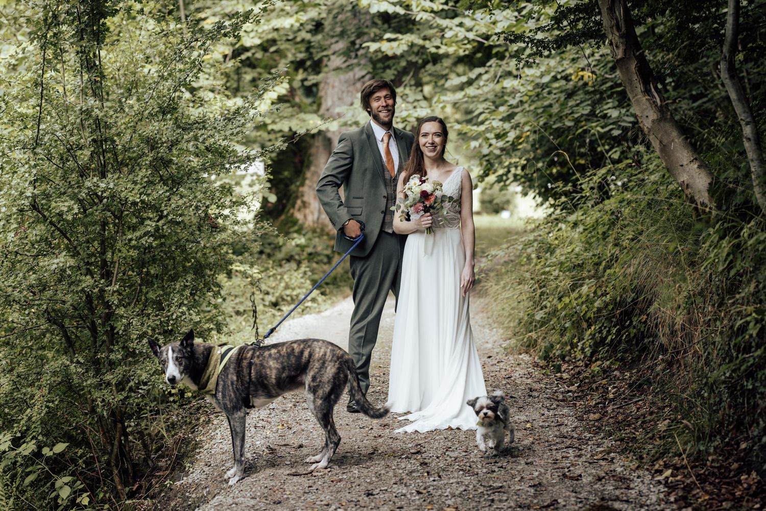 A bride and groom walk hand-in-hand through an elegant stone courtyard of a historic building.