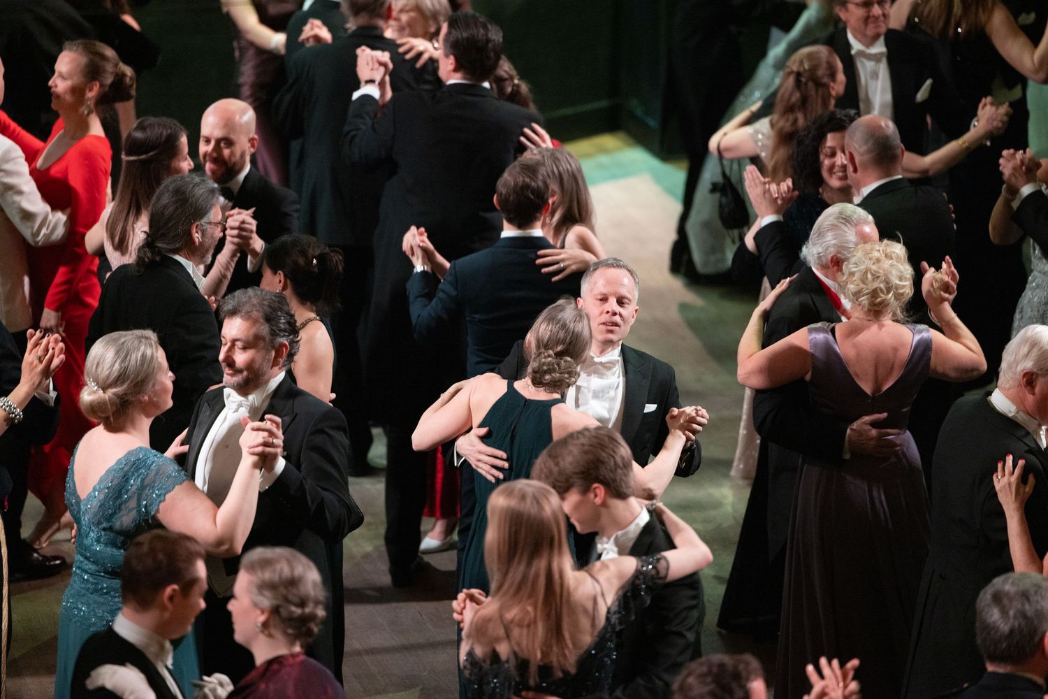 Elegantly dressed couples dancing together on a ballroom floor at a formal gala event.