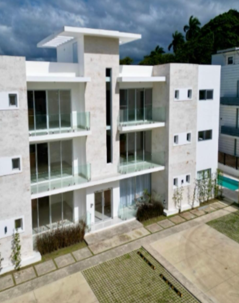 Modern white three-story apartment building with glass balconies, minimalist design, and poolside terrace.