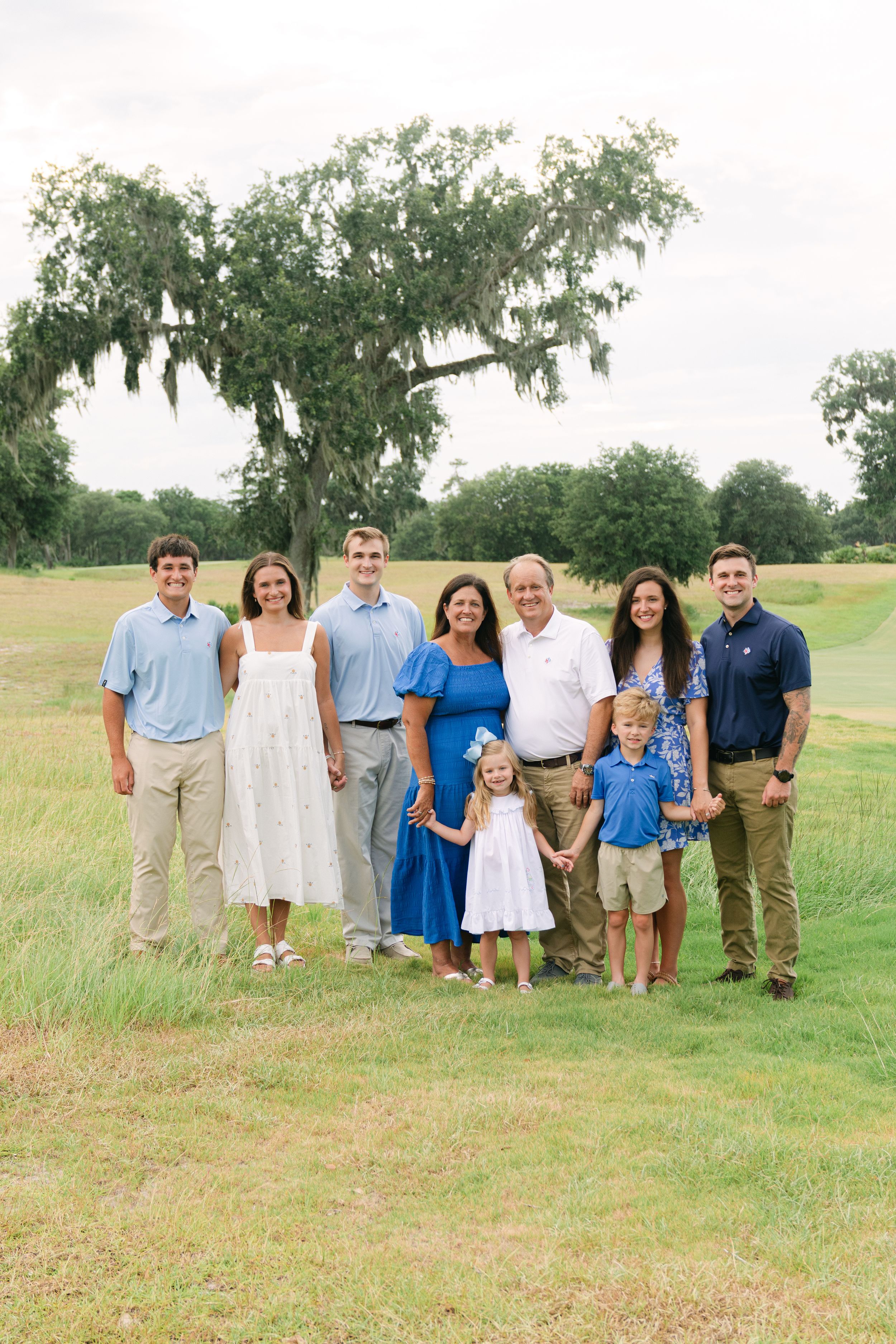 Multi-generational family photo in coordinated cream and blue outfits at Frederica Golf Club.