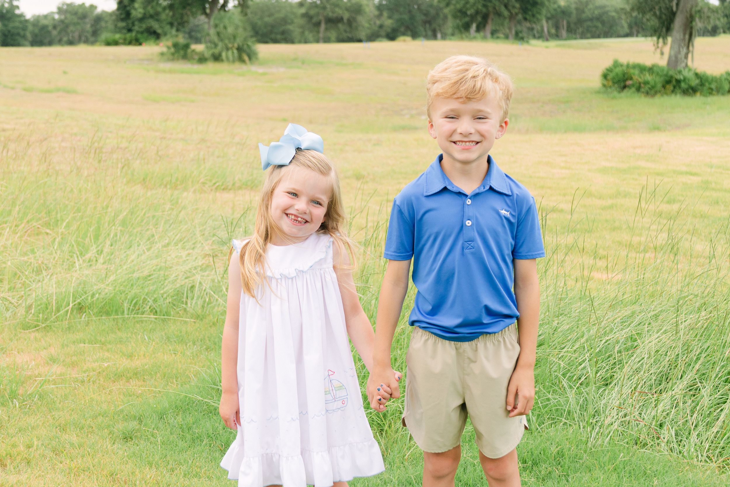 Natural family portrait session with coordinated neutral wardrobe at Frederica Golf Club.