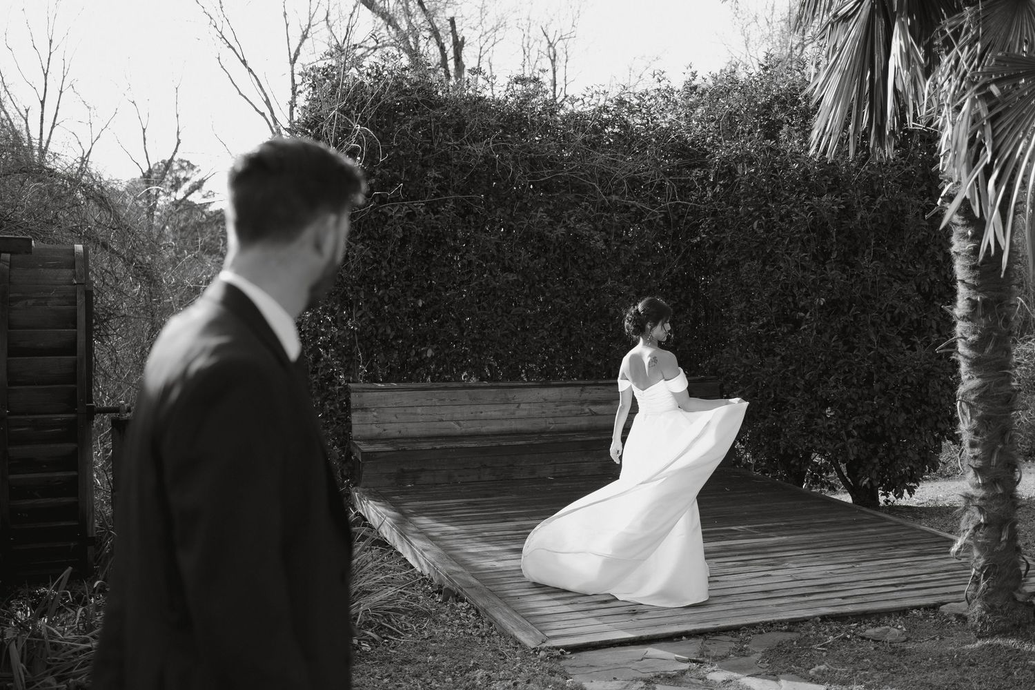 A flowing white wedding dress catches the wind in a romantic outdoor setting.