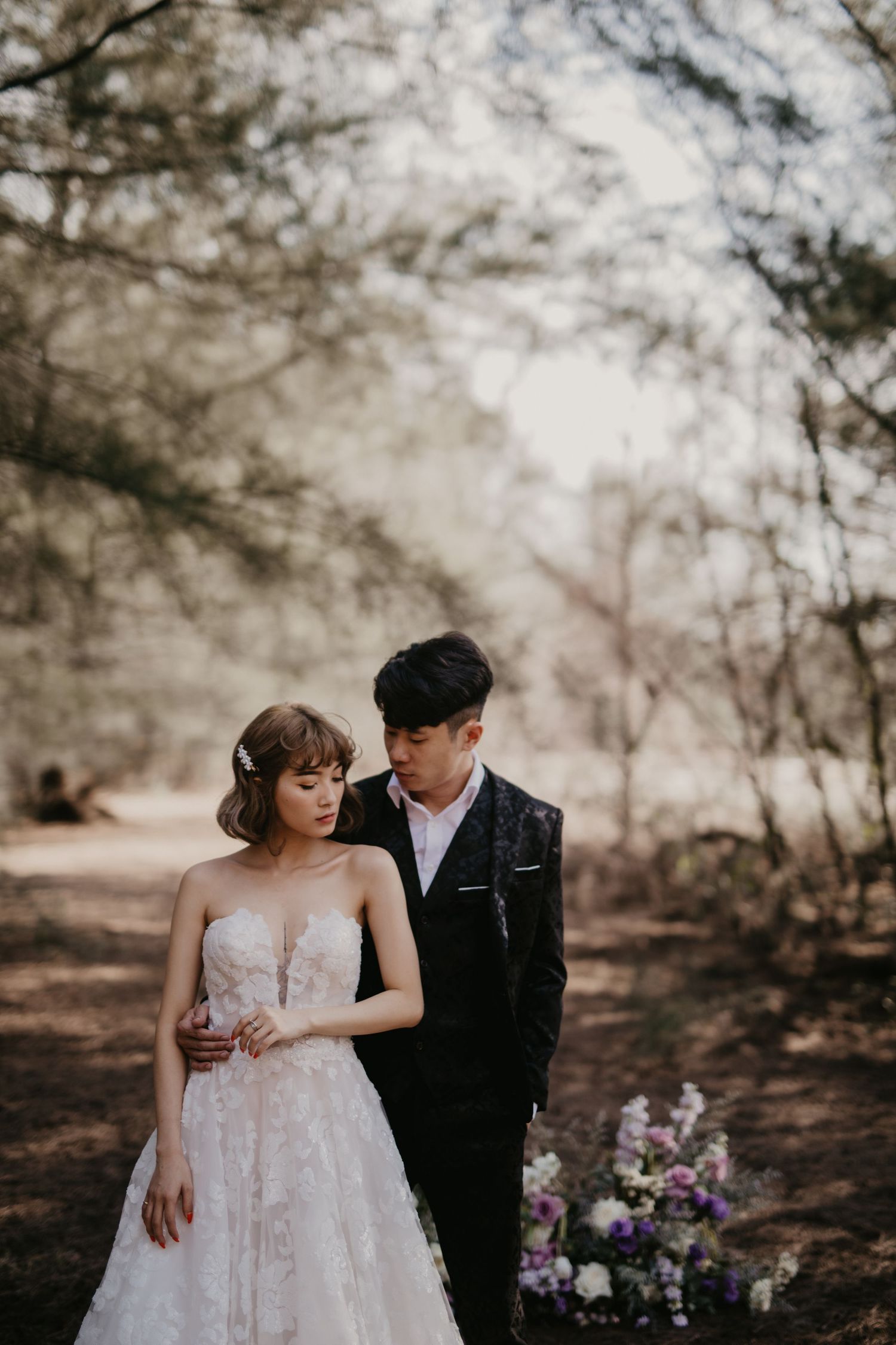 Romantic forest wedding portraits with elegant white dress and natural lighting.
