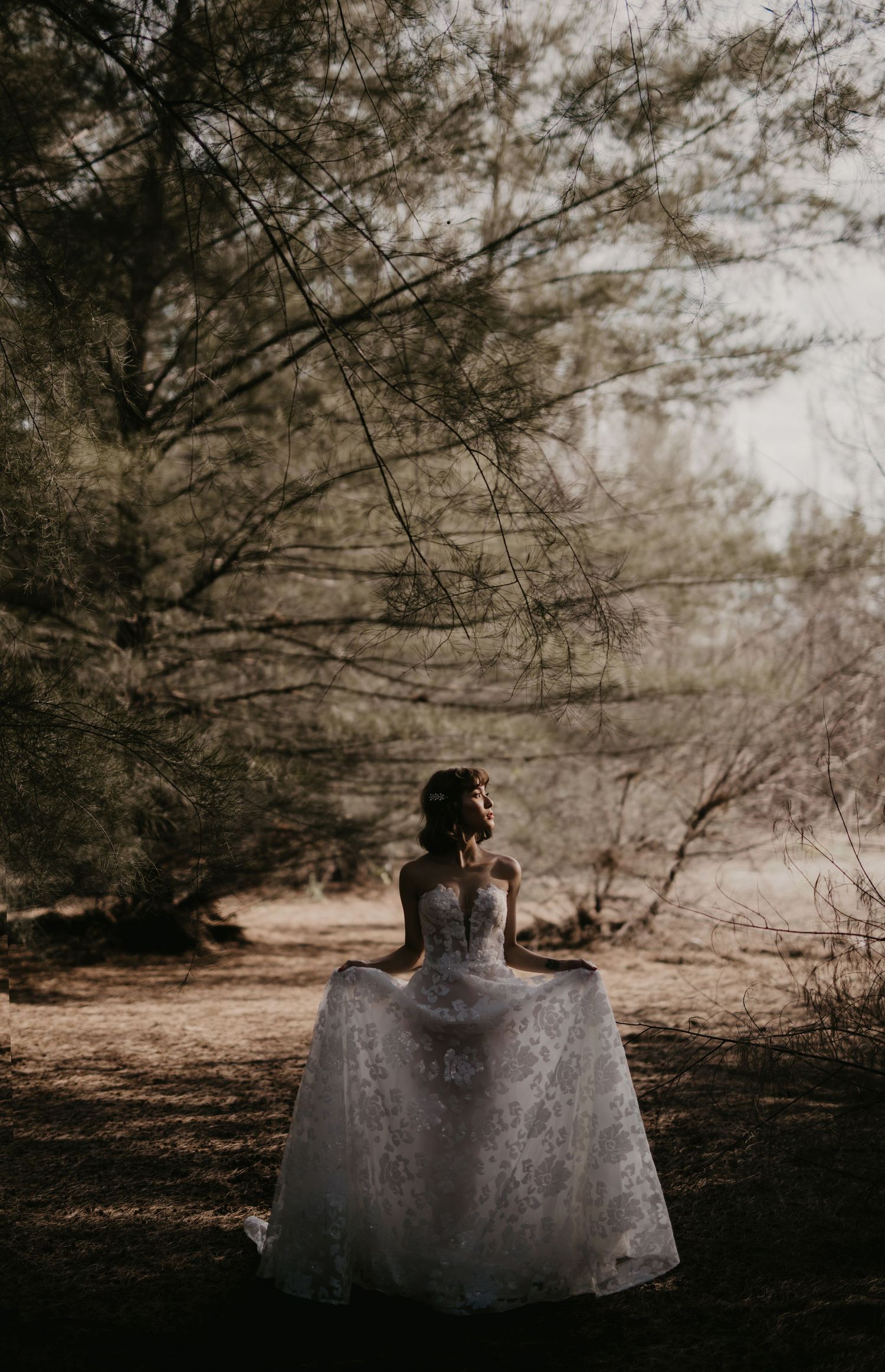 A dreamy wedding dress silhouette photographed against a forest backdrop.