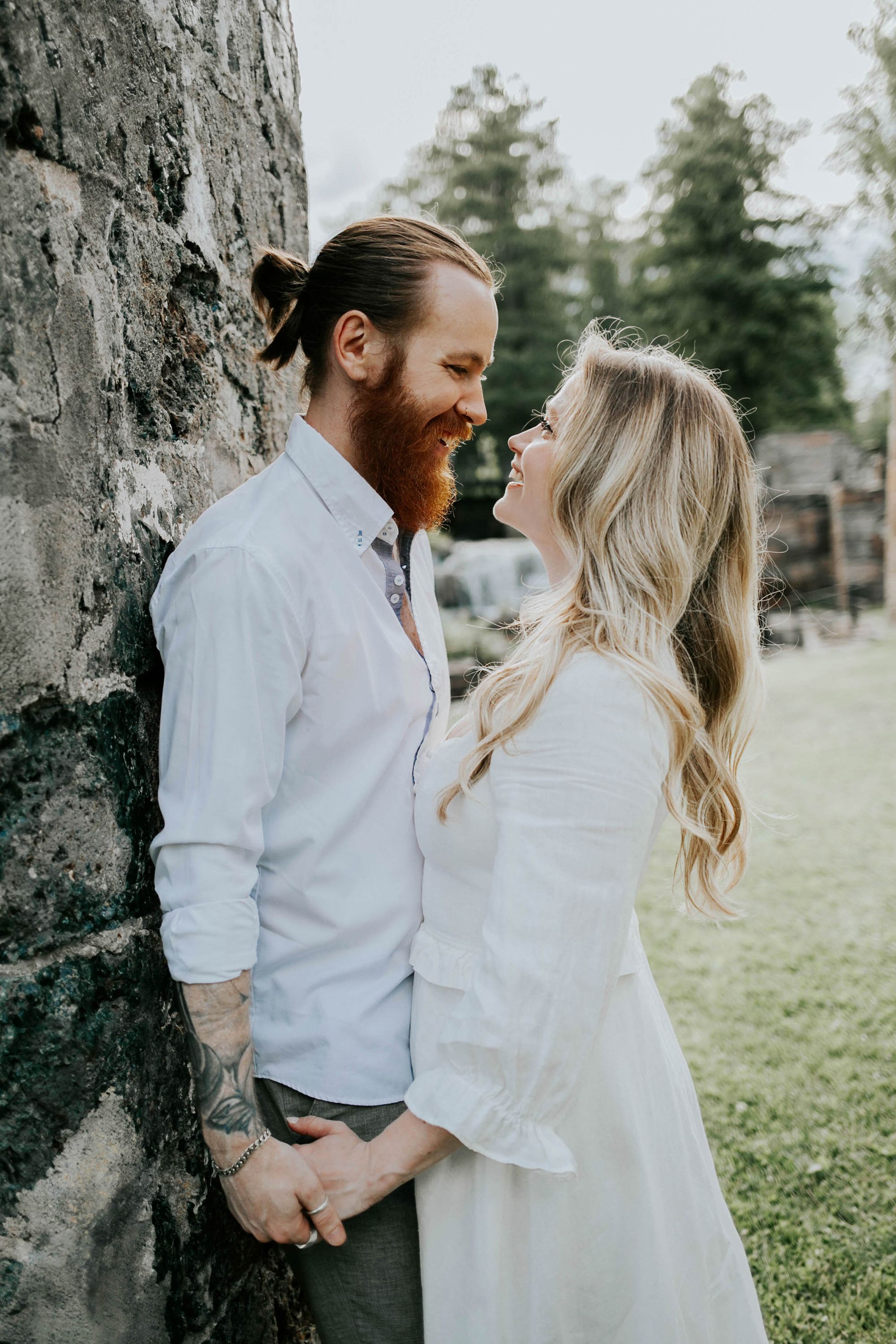 Kärleksfotografering i Borgvik med Julia och Martin. Borgvik utanför Karlstad. fotograf Rebecca Nordin. Hon lutar sig mot honom.