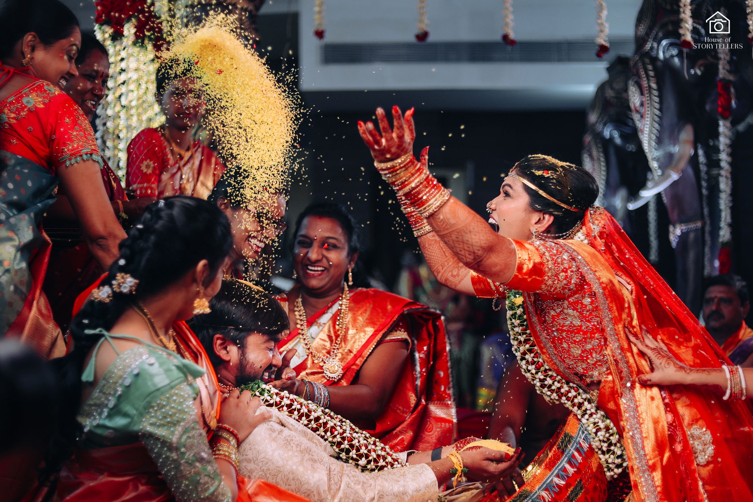 Joyous celebration with turmeric powder being thrown during South Indian wedding festivities.