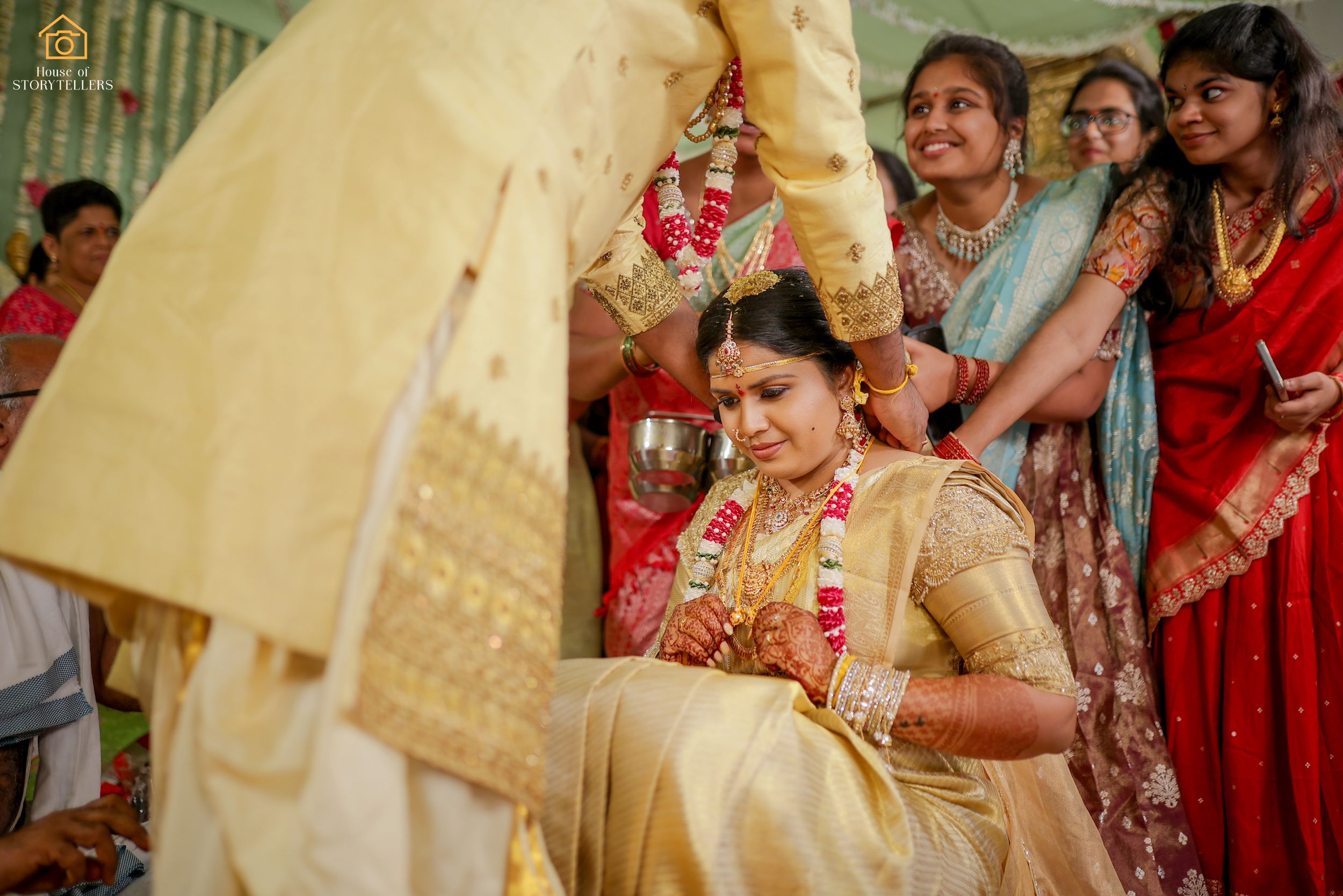 Traditional Indian wedding ceremony with guests gathering around during ritual celebrations.
