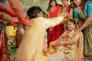 Joyful wedding celebration with guests participating in traditional Indian ceremonies.