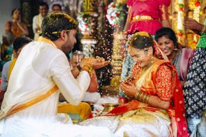 Traditional wedding ritual with turmeric powder being exchanged during South Indian ceremony.
