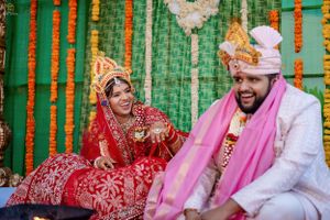 Couple in traditional wedding attire sharing a joyful moment during their ceremony.