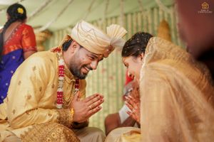 Traditional South Indian wedding ceremony with couple in festive attire exchanging greetings.