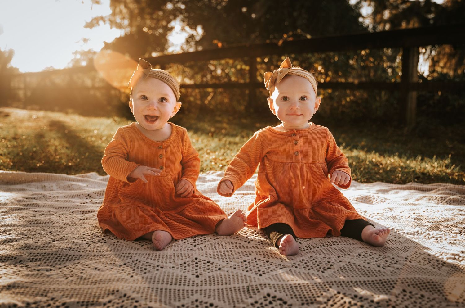 Fall Twin babies smiling on a crochet blanket while sun rays enhance the portrait. Jacksonville, Florida photographer