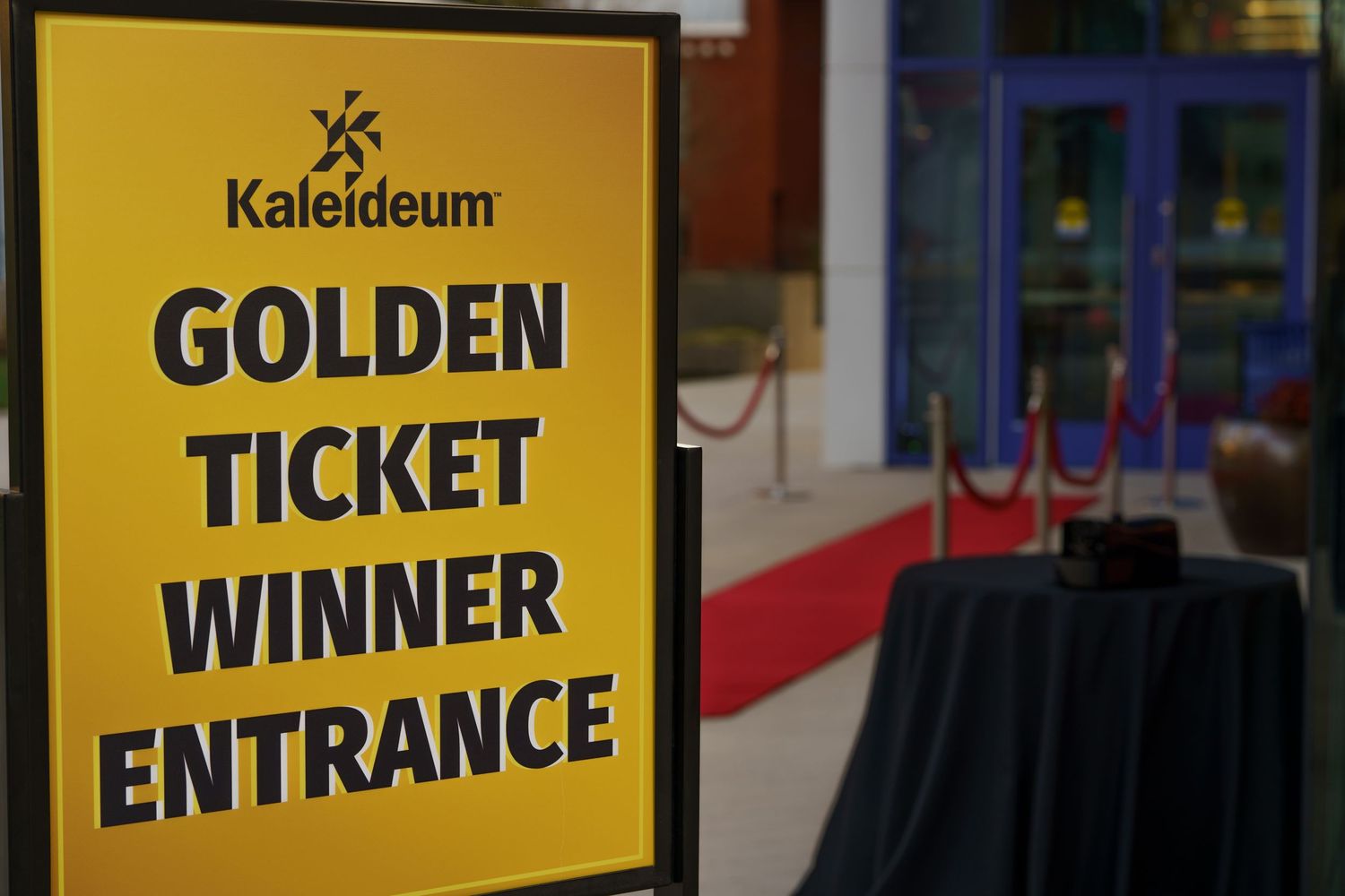 Yellow signs displaying entrance and ticket information at an entertainment venue.