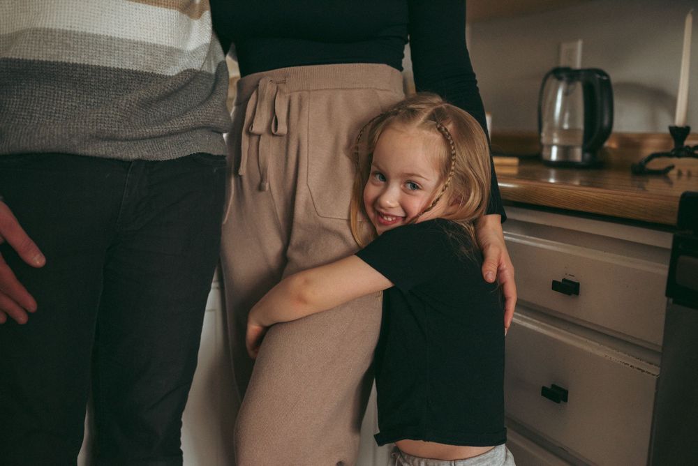 A warm embrace shared between parent and child in a cozy kitchen setting.