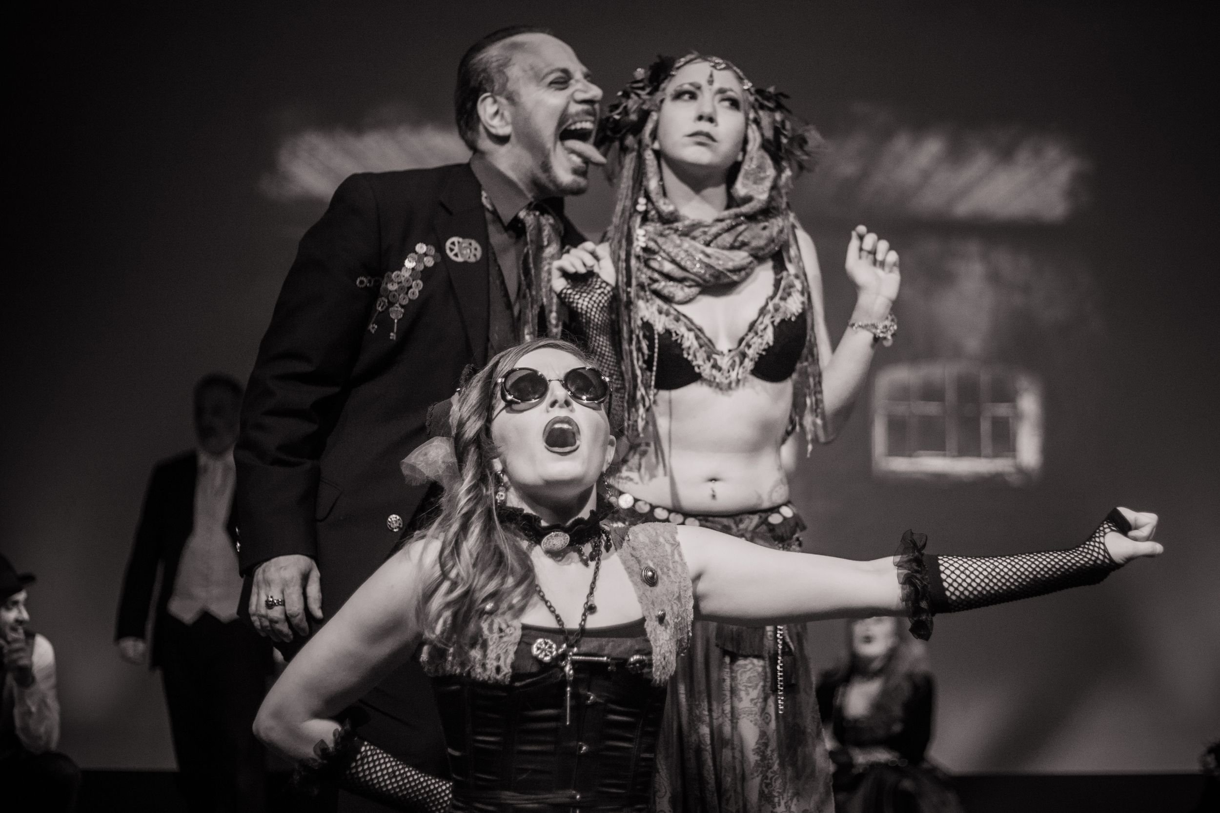 Performers in alternative costumes express dramatic emotions during stage production.
