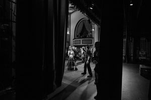 Silhouetted figures visible through a backstage archway during a performance.