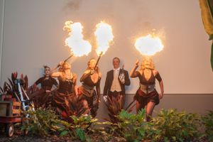 Fire performers breathe flames in unison during an evening outdoor show.