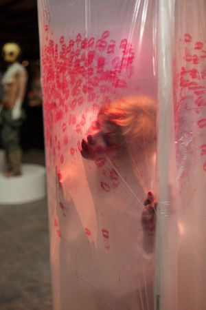 Artistic installation with red lighting behind translucent material creating ethereal effect.