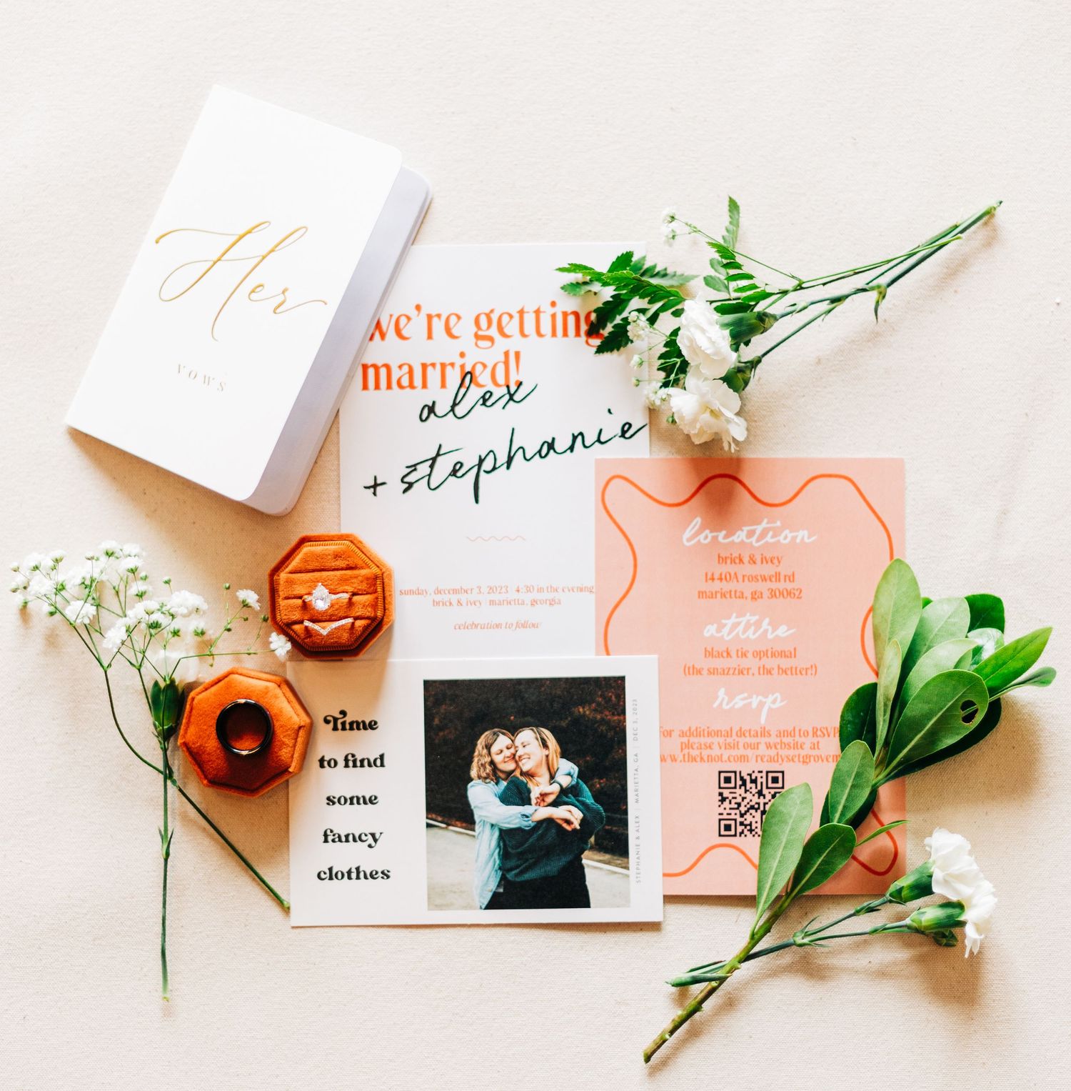 Wedding stationery flatlay with peach flowers and engagement announcement cards.