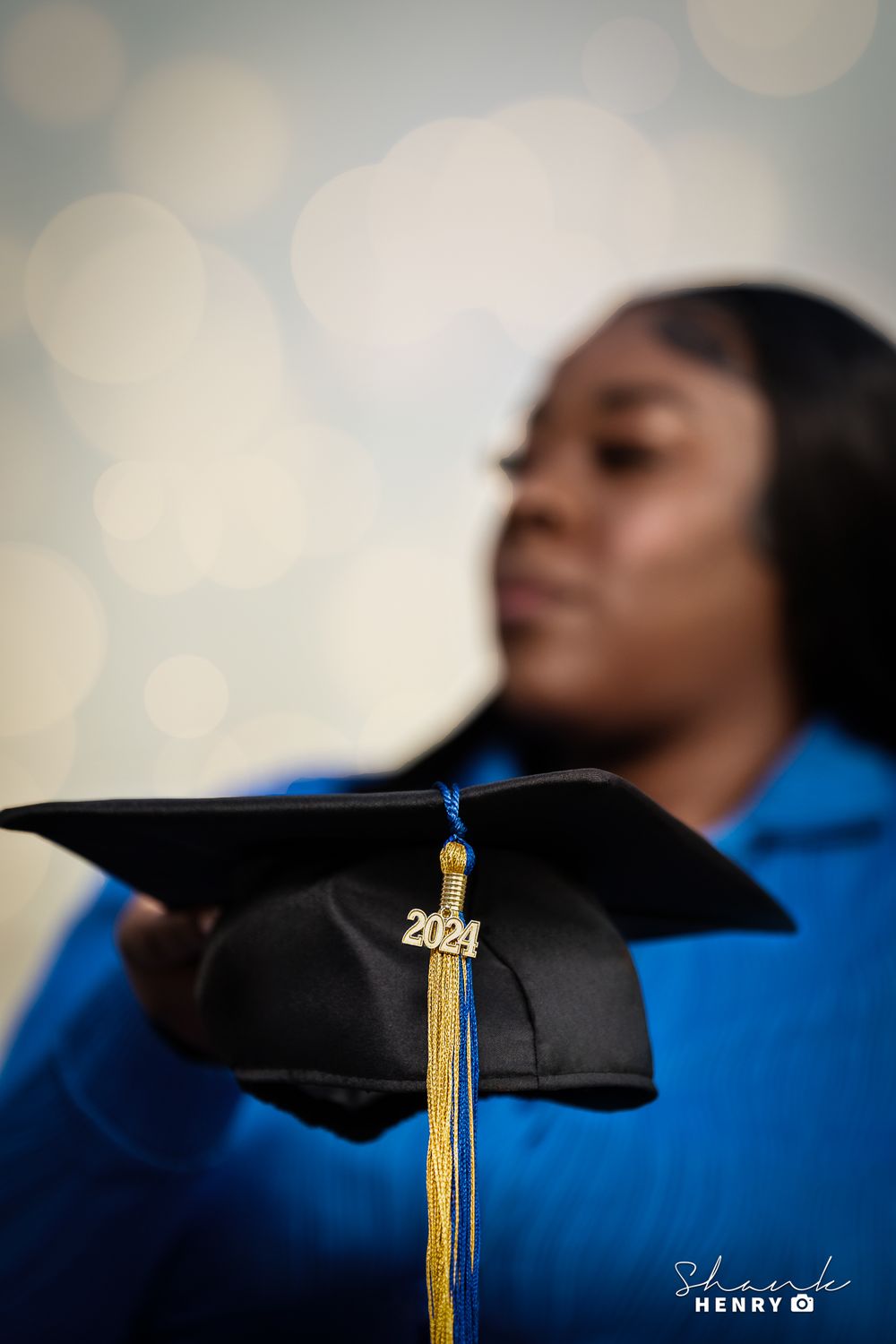 A close-up shot of a 2021 graduation cap with gold tassel against a bokeh background.