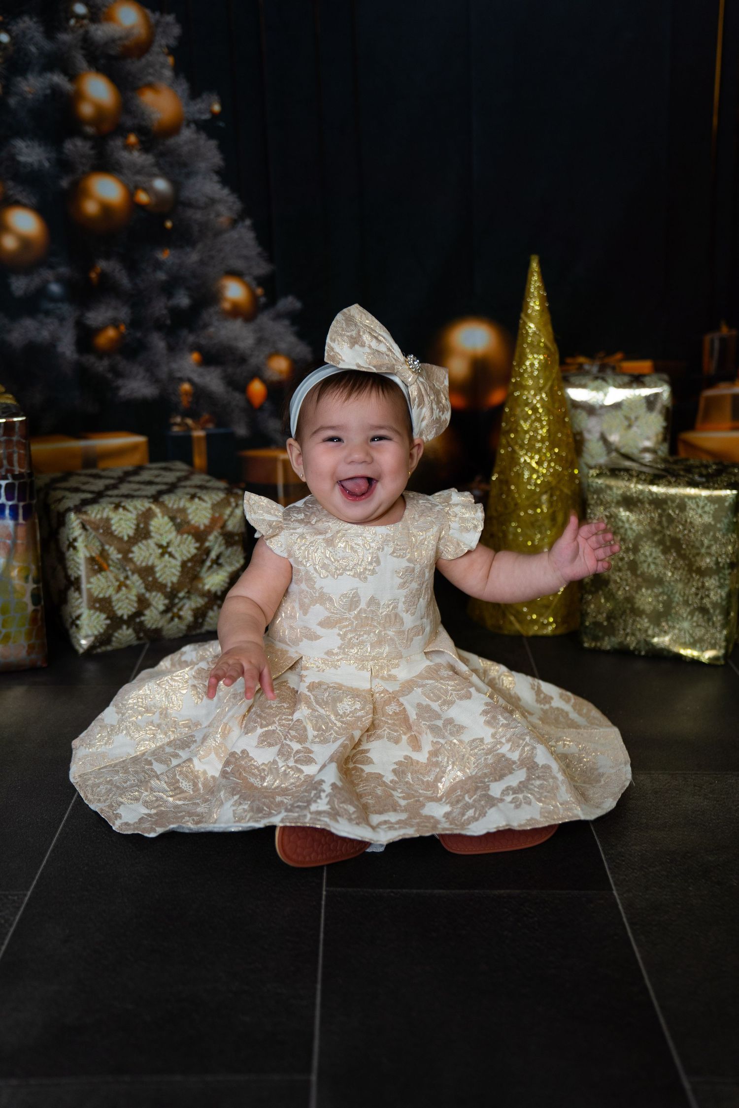 Holiday portrait with festive dress against Christmas tree with gold ornaments.