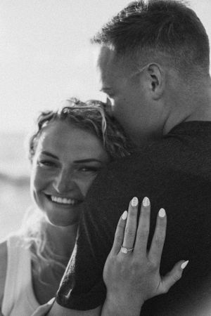 Black and white photos capturing intimate moments during a beach proposal.