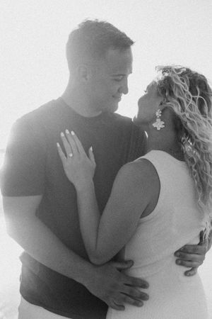 Intimate black and white portrait of a romantic couple in a tender embrace.